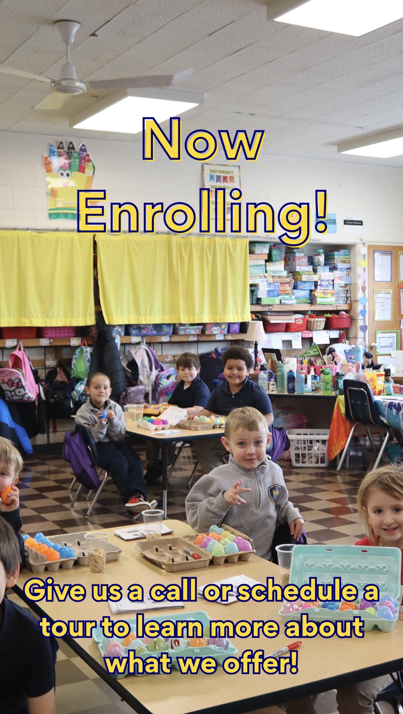 Now Enrolling with children smiling at the camera at their desks