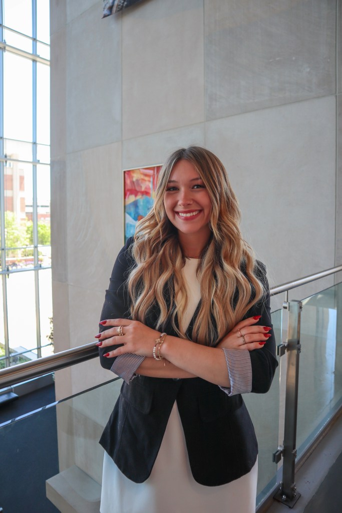 Alexia posing with her arms crossed, smiling for a professional photo